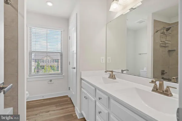 a bathroom with a double vanity sink a mirror and a shower