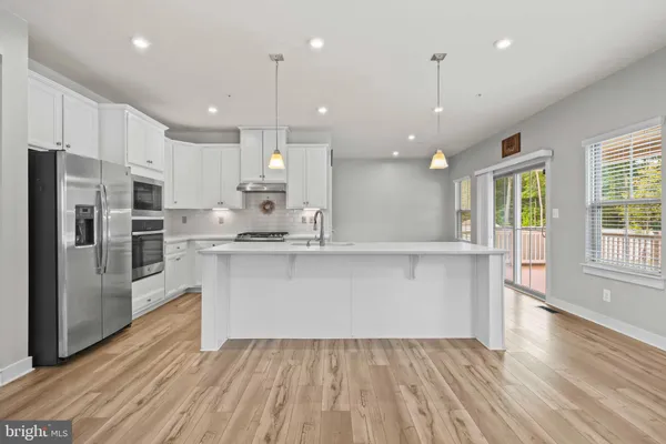 a kitchen with granite countertop a stove a sink and a refrigerator