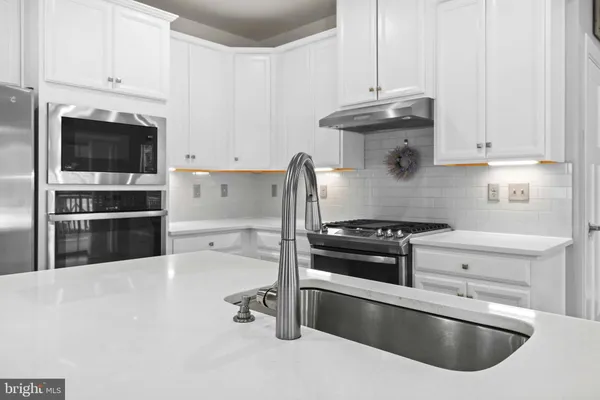 a view of a kitchen sink and wooden floor