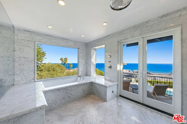 a spacious bathroom with a double vanity sink a mirror a bathtub and a window