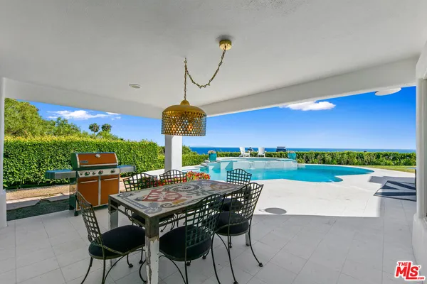 a view of a patio with dining table and chairs with a swimming pool