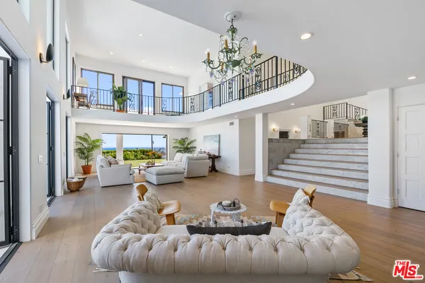a living room with furniture and a chandelier