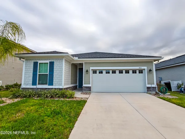 a front view of house with yard and garage