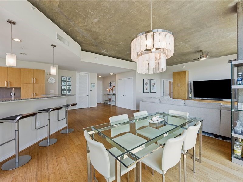 5925 Almeda Road, Unit 10714 Houston, TX 77004 - Photo 3 of 38 a view of a dining room with furniture a chandelier and wooden floor