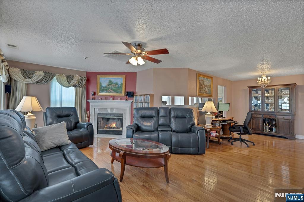 72 Marrow Street, Unit 3101 Newark, NJ 07103 - Photo 5 of 20 a living room with furniture a fireplace and a large mirror with wooden floor