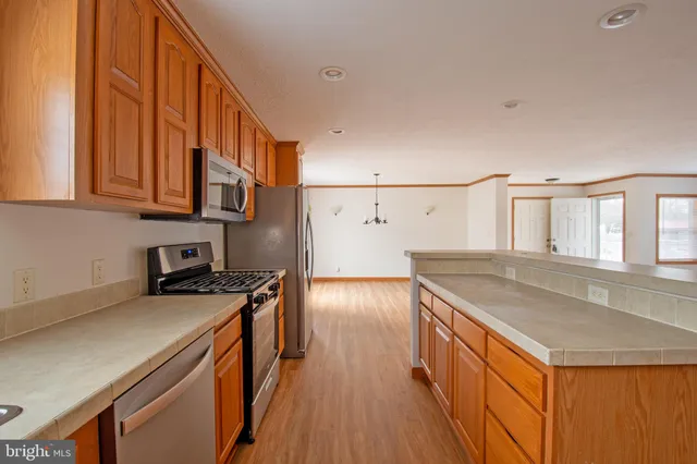 a kitchen with granite countertop a sink a stove and wooden cabinets