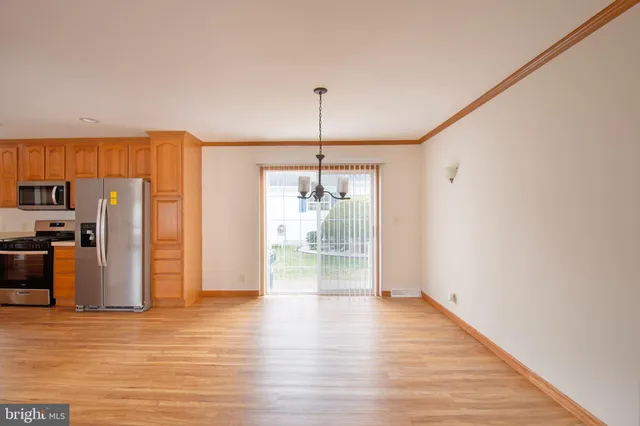 a view of a kitchen with wooden floor and a window