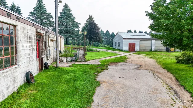 a view of a house with a big yard and large trees