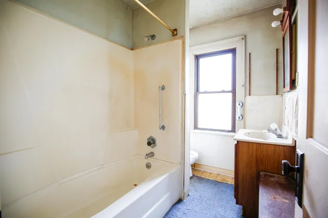 a bathroom with a bathtub a sink and a window