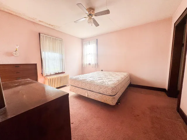 a spacious bedroom with a bed and a chandelier