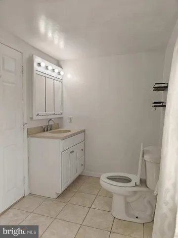 a bathroom with a granite countertop sink a toilet and a mirror
