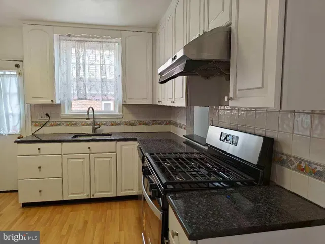 a kitchen with granite countertop a stove and a sink