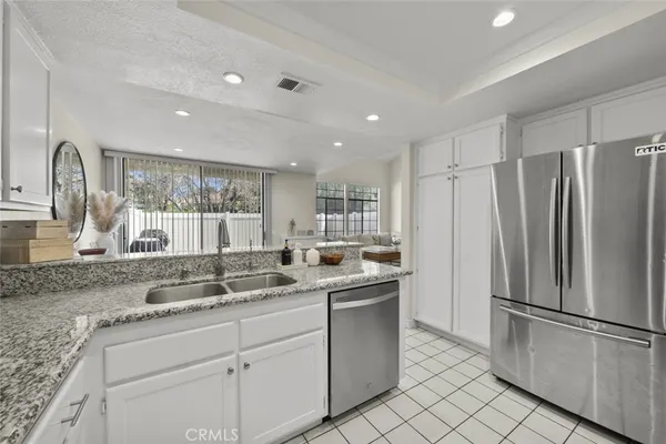 a kitchen with stainless steel appliances granite countertop a sink a refrigerator and a granite counter tops