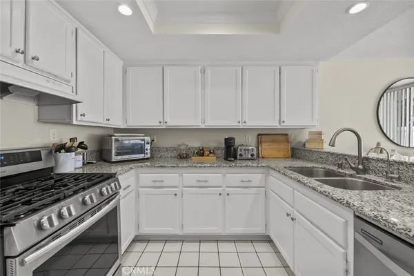 a kitchen with granite countertop white cabinets and white appliances