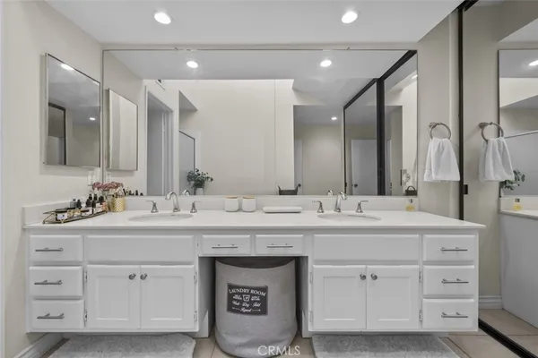 a bathroom with double sink and a mirror