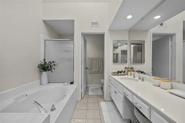 a bathroom with a tub a sink and mirror