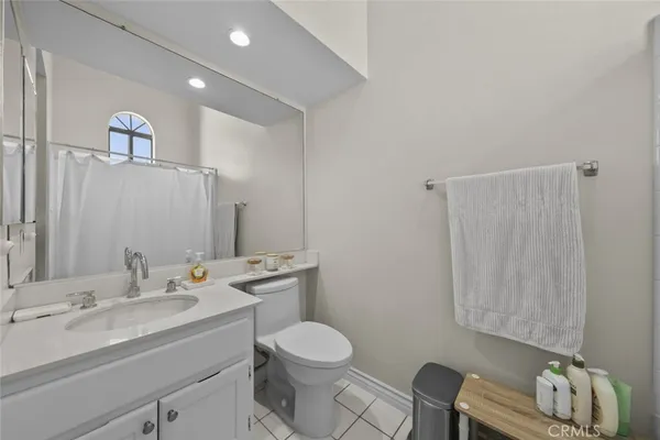 a bathroom with a granite countertop sink mirror vanity and toilet