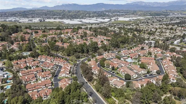 an aerial view of residential houses with outdoor space and trees
