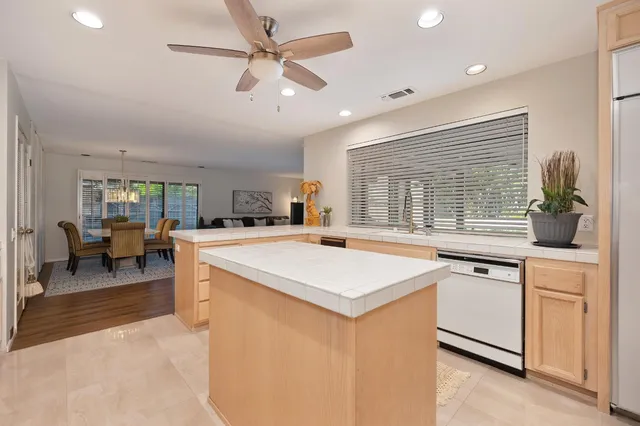 a view of center kitchen island a stove a sink a dining table and chairs