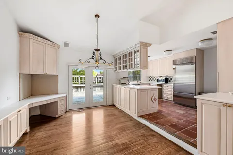 a kitchen with stainless steel appliances kitchen island granite countertop a stove top oven a sink a counter space and cabinets