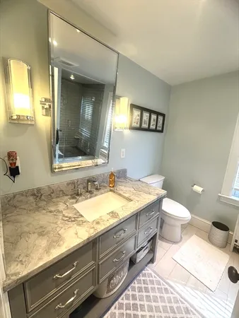 a bathroom with a granite countertop sink and a mirror