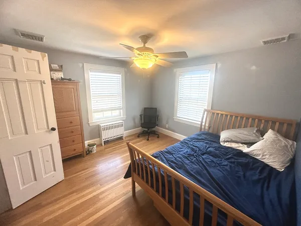 a bedroom with a bed and wooden floor