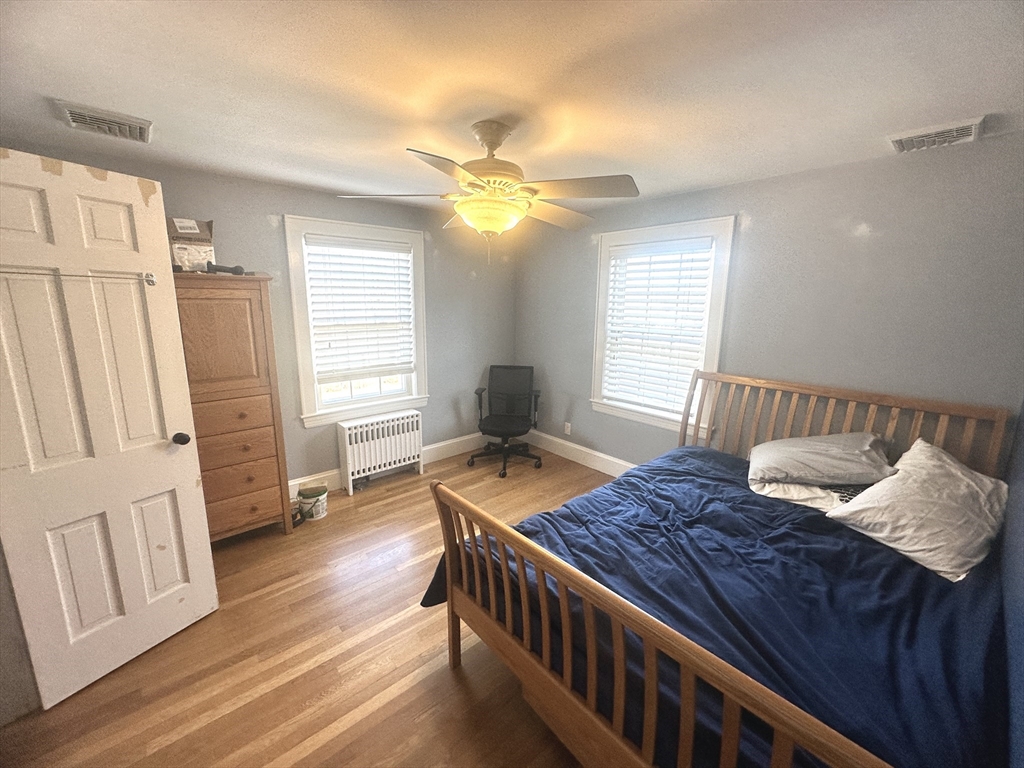 164 Florence Road Waltham, MA 02453 - Photo 16 of 19 a bedroom with a bed and wooden floor