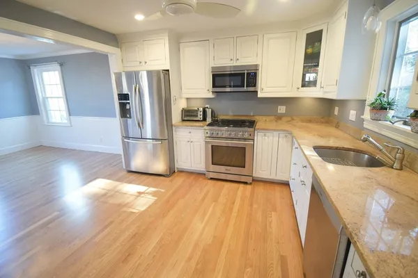 a kitchen with a sink a microwave a refrigerator and cabinets