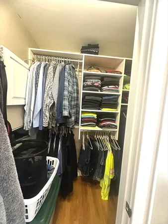 a view of walk in closet with clothes and shoes