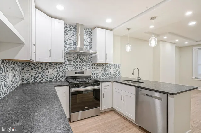 a kitchen with stainless steel appliances granite countertop a sink stove and cabinets