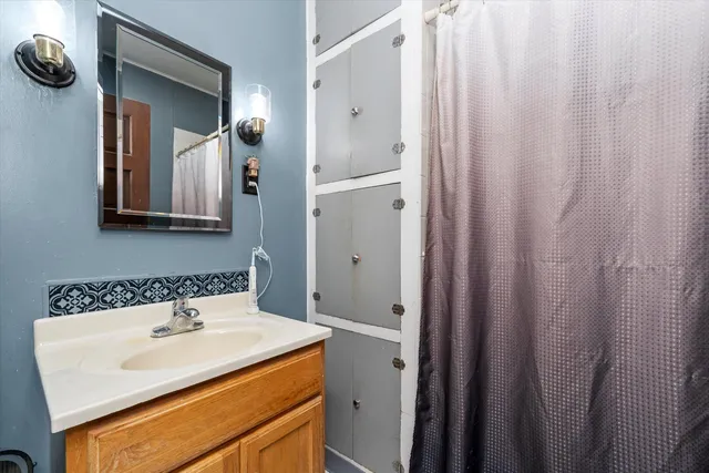 a bedroom with a bed window and walk in closet with wooden floor