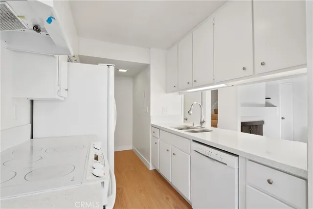 a kitchen with white cabinets and sink