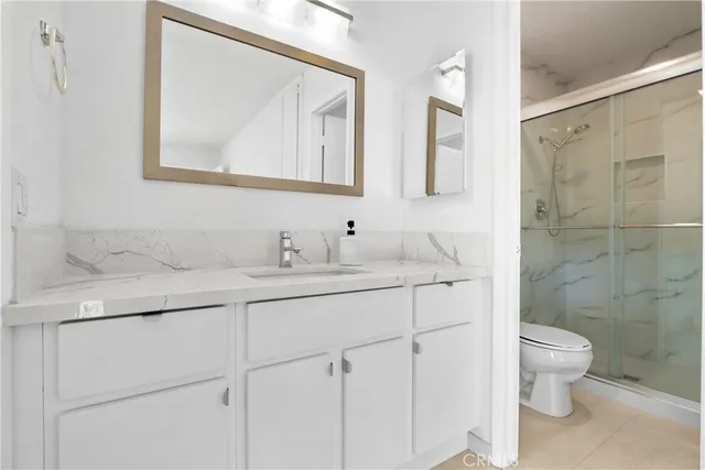 a bathroom with a toilet a sink a vanity and mirror