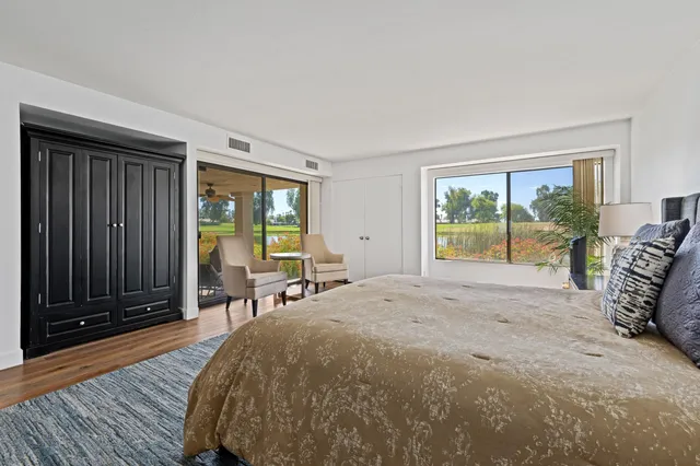 a bed sitting in a spacious bedroom next to a window
