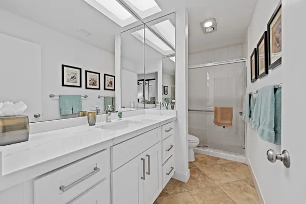 a en suite bathroom with a double vanity sink a mirror and a shower