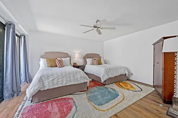 a bedroom with two beds and wooden floor