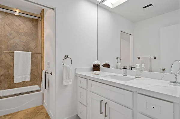a bathroom with a double vanity sink and mirror with shower
