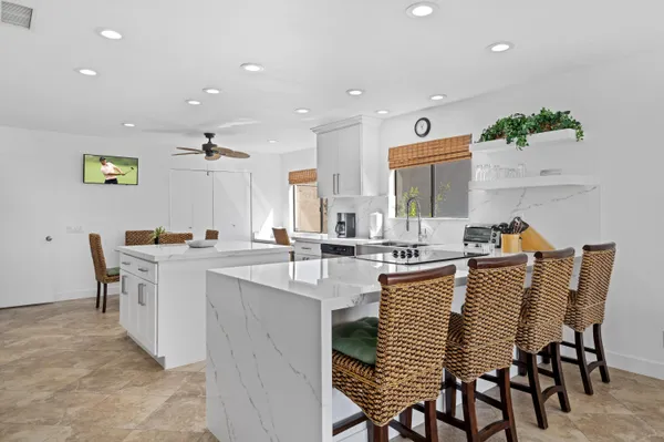 a kitchen with stainless steel appliances a sink a stove a table and chairs
