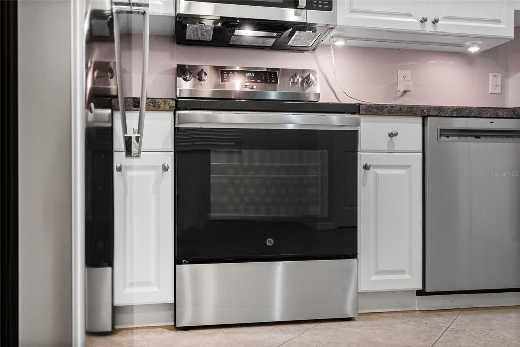 1050 Starkey Road, Unit 704 Largo, FL 33771 - Photo 12 of 27 a kitchen with stainless steel appliances granite countertop a stove and a refrigerator