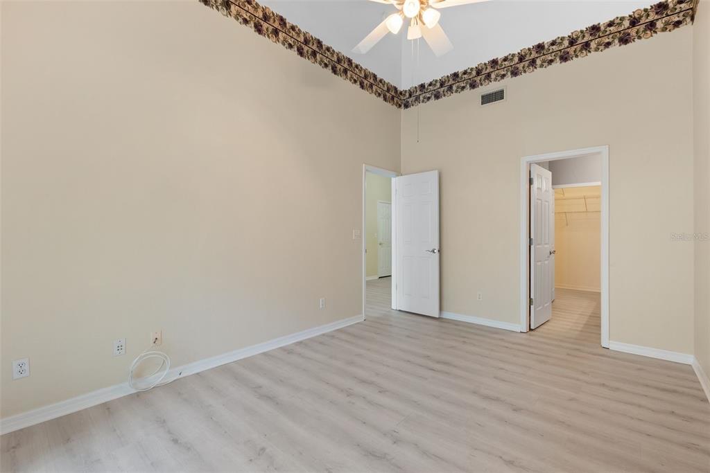1050 Starkey Road, Unit 704 Largo, FL 33771 - Photo 14 of 27 an empty room with a chandelier fan and wooden floor