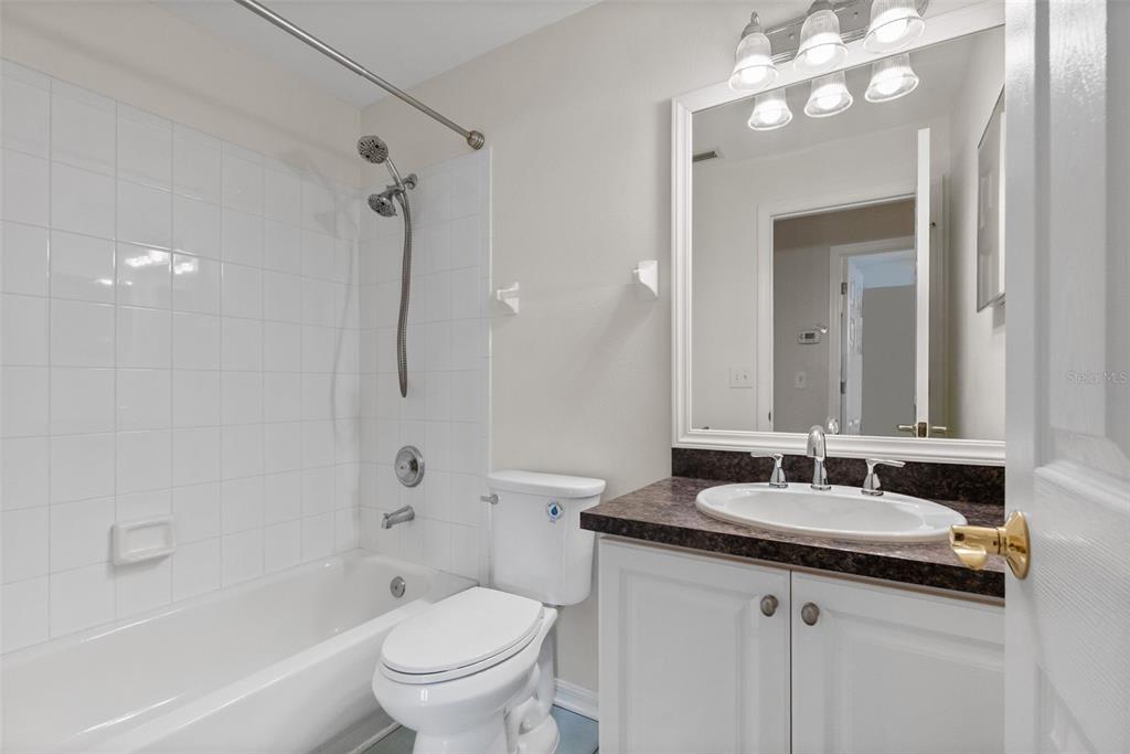 1050 Starkey Road, Unit 704 Largo, FL 33771 - Photo 22 of 27 a bathroom with a granite countertop sink a toilet and shower