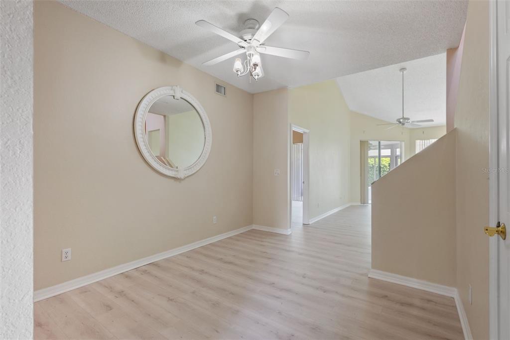 1050 Starkey Road, Unit 704 Largo, FL 33771 - Photo 6 of 27 an empty room with wooden floor and mirror
