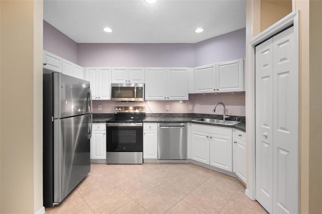 1050 Starkey Road, Unit 704 Largo, FL 33771 - Photo 10 of 27 a kitchen with stainless steel appliances granite countertop a refrigerator and a stove top oven