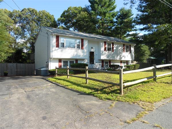 a view of a house with backyard and a tree