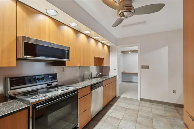 a kitchen with stainless steel appliances a stove a sink and a refrigerator