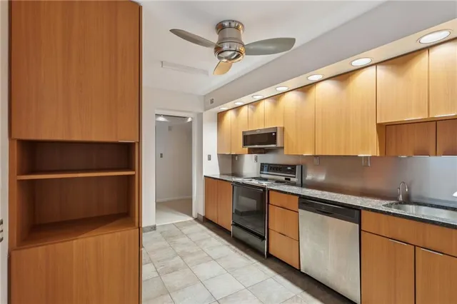 a kitchen with stainless steel appliances granite countertop a sink a stove and a refrigerator