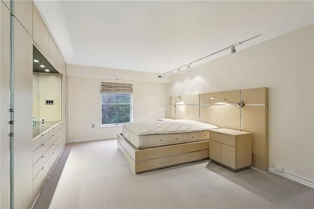 a spacious bedroom with a bed and a dresser