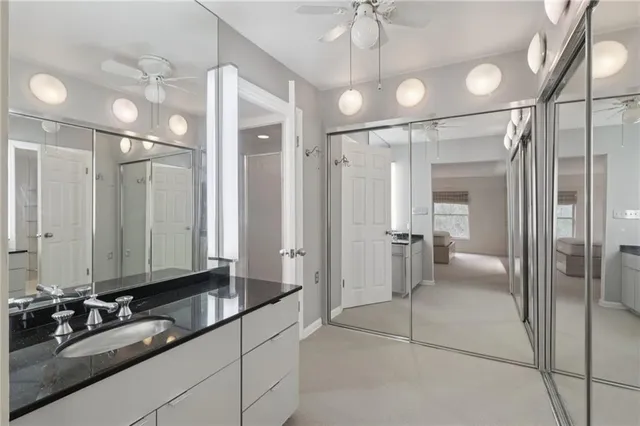 a bathroom with a granite countertop sink a toilet and shower
