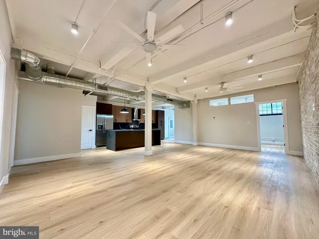 a view of a big room with wooden cabinet and windows