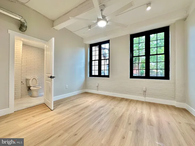 an empty room with wooden floor and windows